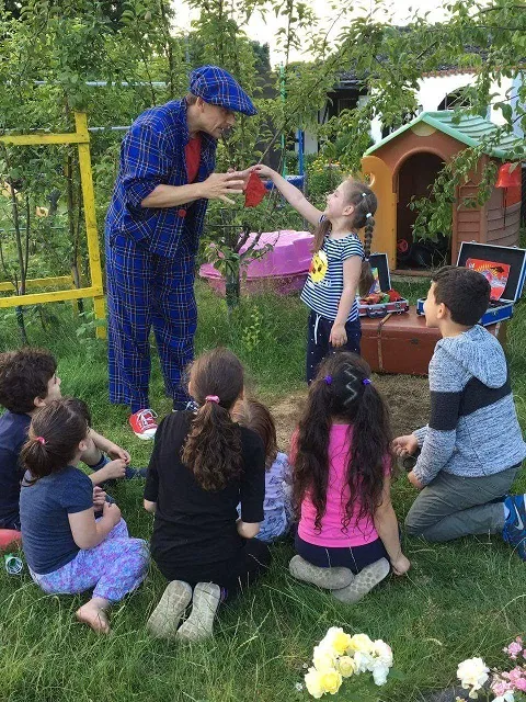 Le magicien pour enfants LIAR présente des tours de magie lors d'un anniversaire d'enfant dans le jardin