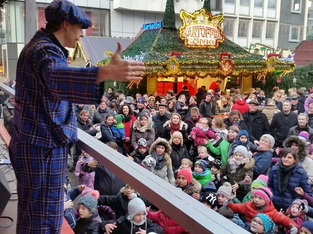 Le clown LIAR lors d'un spectacle sur scène sur un marché de Noël devant un large public