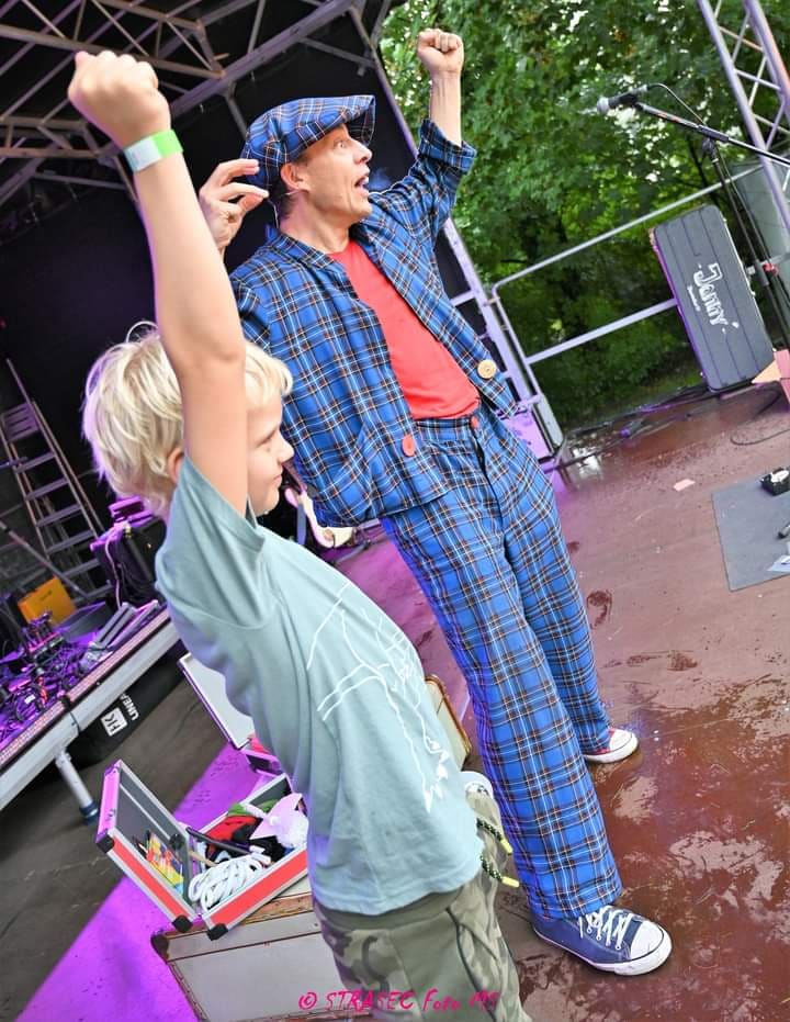 Ein Junge jubelt mit Clown Zauberer LIAR auf der Festivalbühne