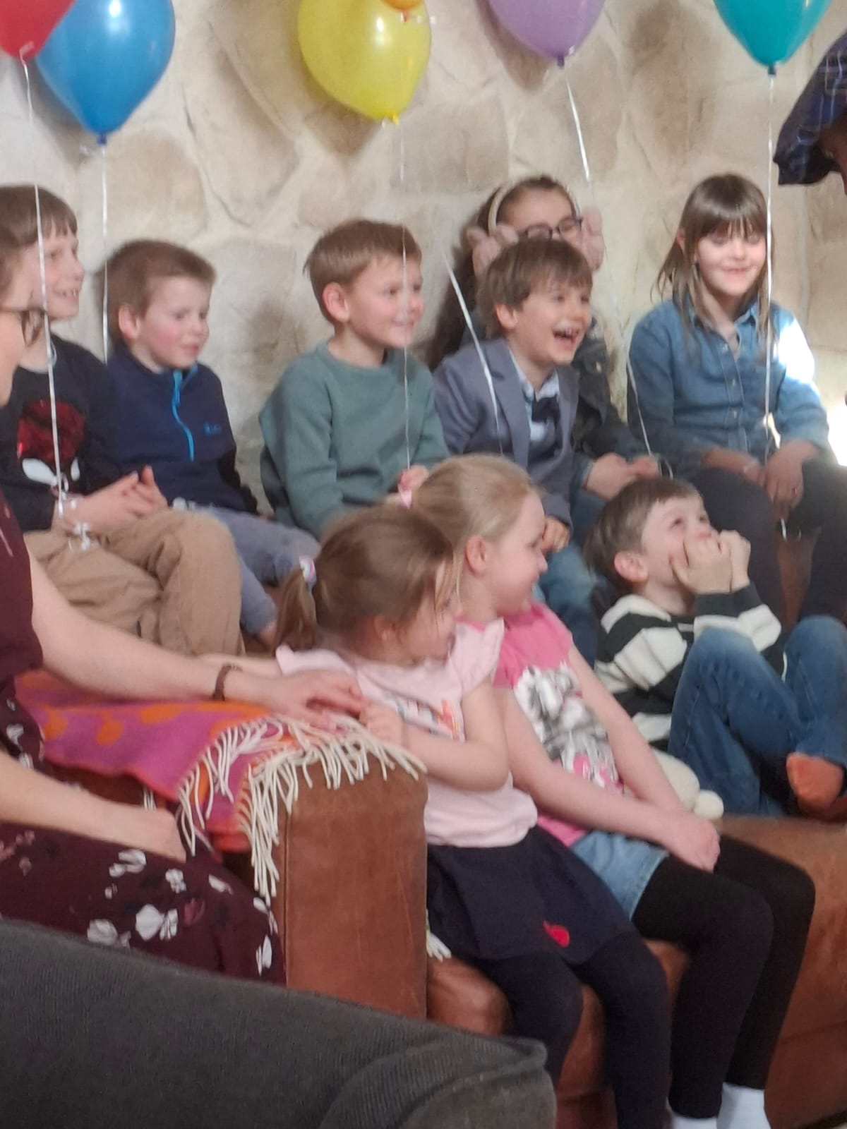 Clown Zauberer bei einer Ballonmodellage im Park mit lachenden Kindern