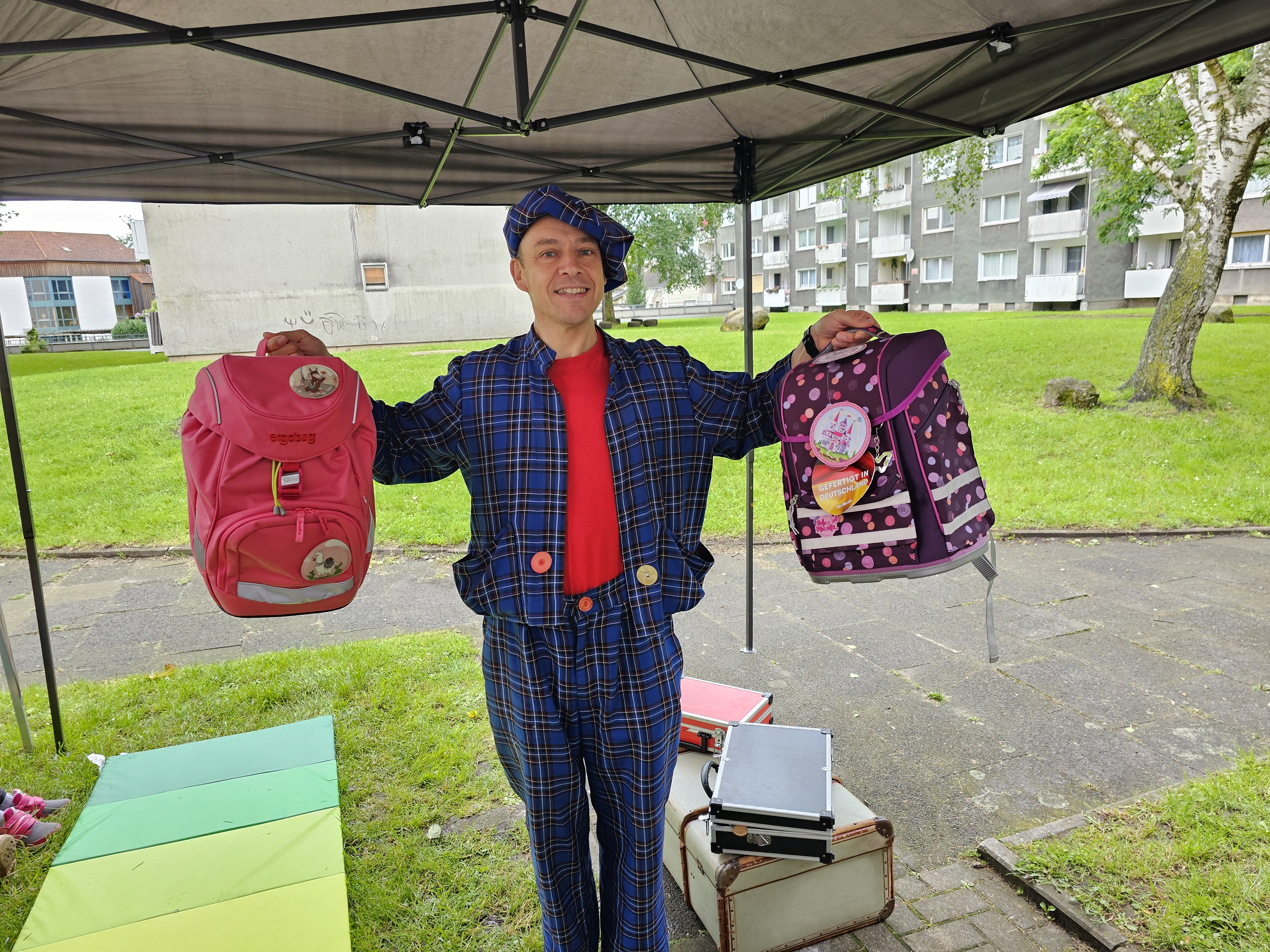 Clown Zauberer LIAR zaubert draußen im Garten für eine Gruppe Kinder im Halbkreis