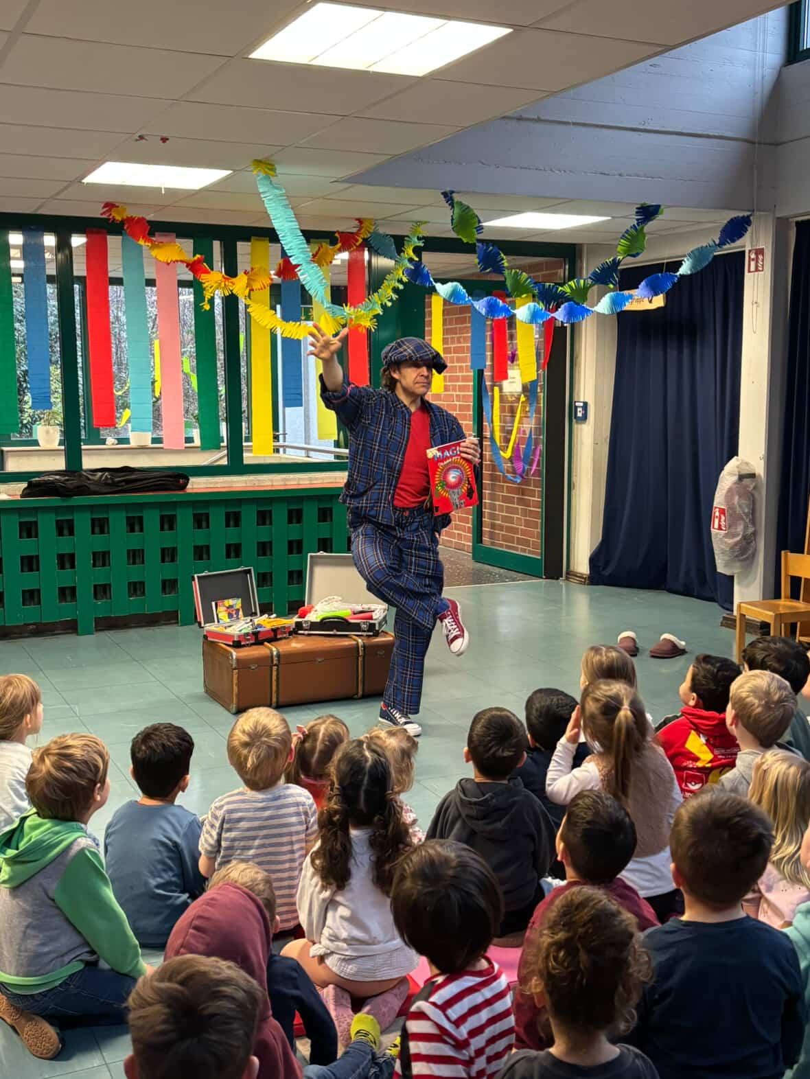 Kinder beim Sommerfest in der Kita lachen ueber den Clown im Garten
